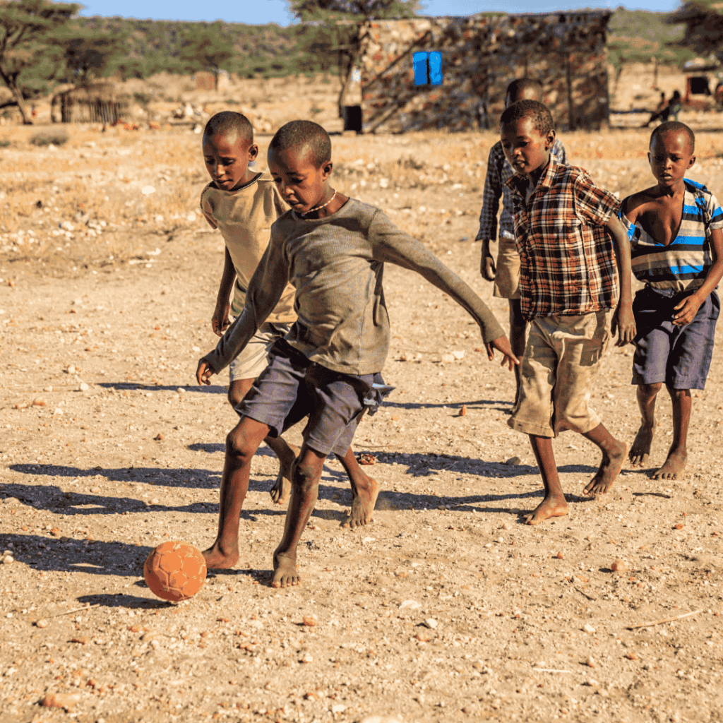 Local African children smiling in a village setting, representing the warmth and hospitality of the regions visited on a tailored African journey.