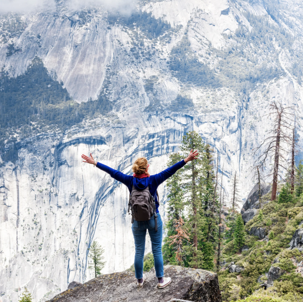 Woman hiking alone on an alpine trail in the mountains during a walking vacation